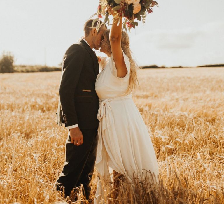 Bride changes from Eliza Jane Howell dress to Ghost wedding dress clutching rustic bouquet