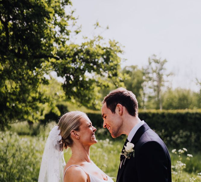 Bride and Groom Embrace with Homemade Veil and Bridal Two Piece