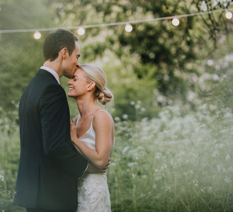 Bride and Groom Embrace with Fairy Lights