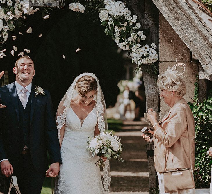 Bride and Groom Church Confetti Moment with Floral Arch Backdrop