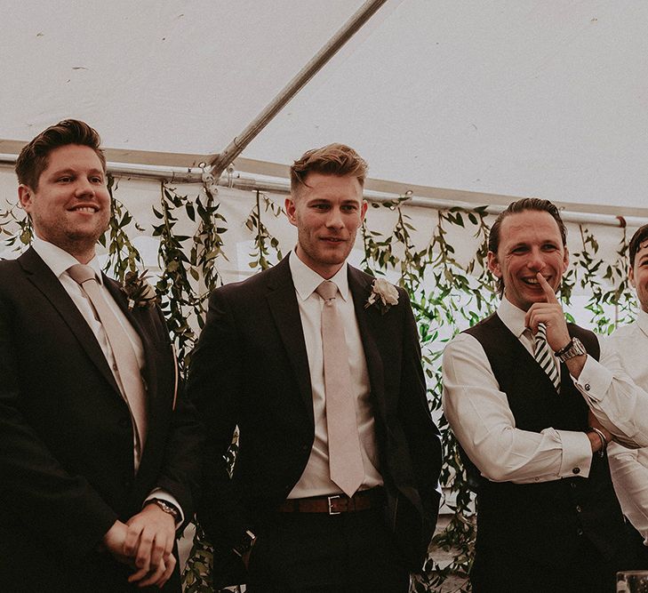 Wedding Guests Standing in From of Foliage Backdrop