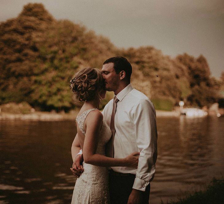 Bride and Groom Embracing By The River Bank