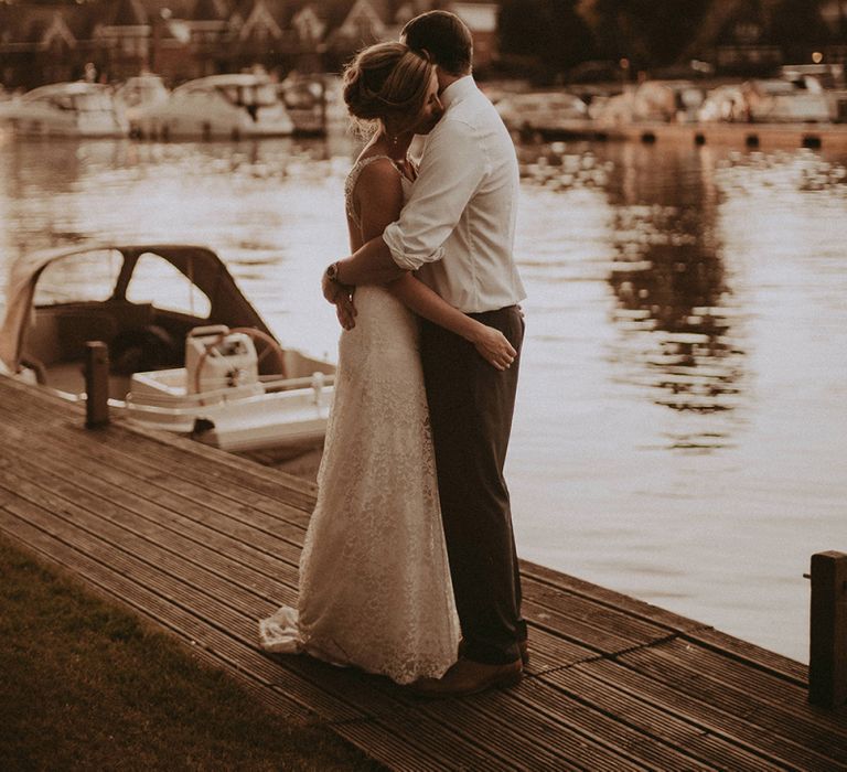 Bride and Groom Embracing by The River Bank