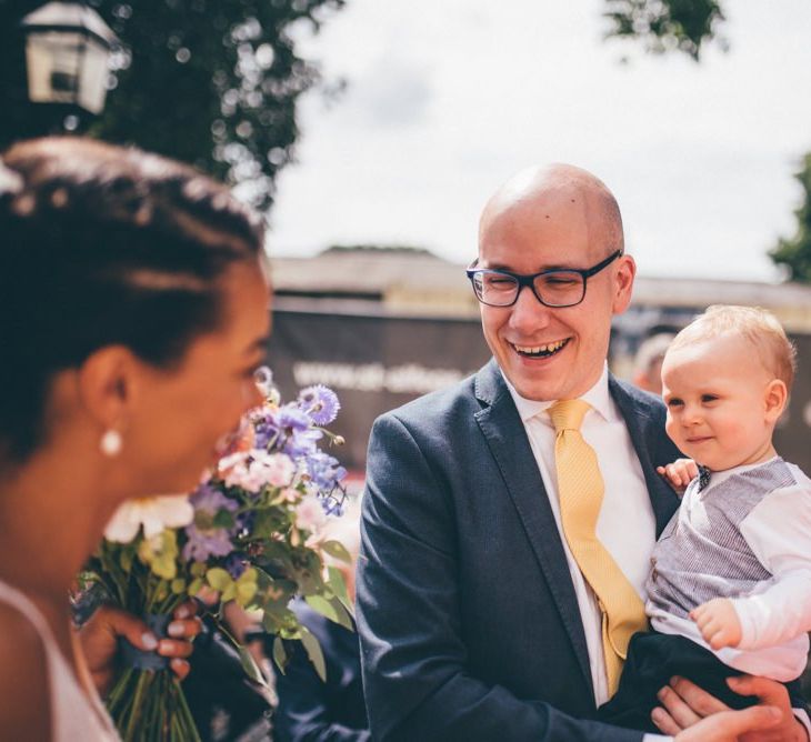 Young guest at city celebration with pink and purple wedding bouquets