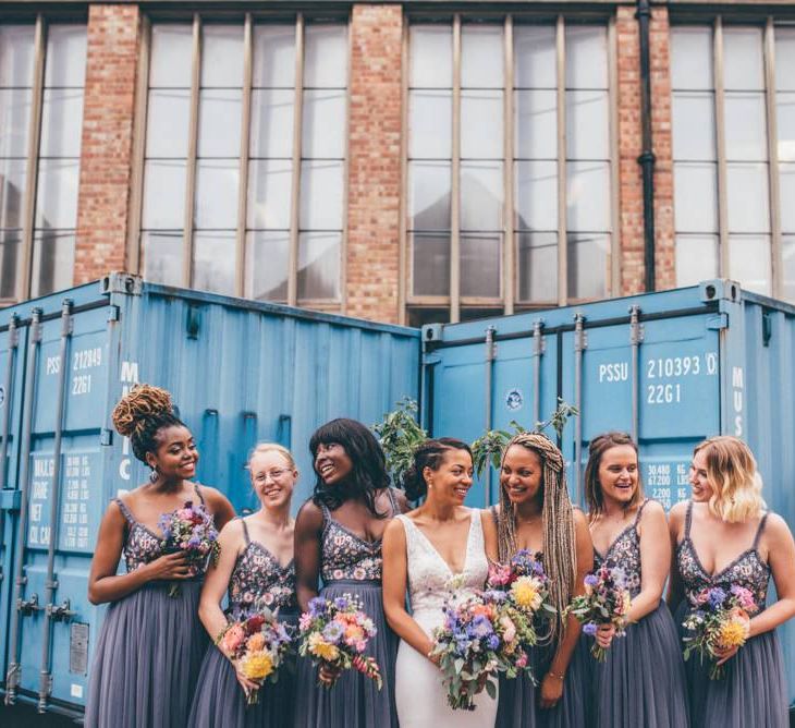 Bride and her bridesmaids with beautiful pink and purple bouquets