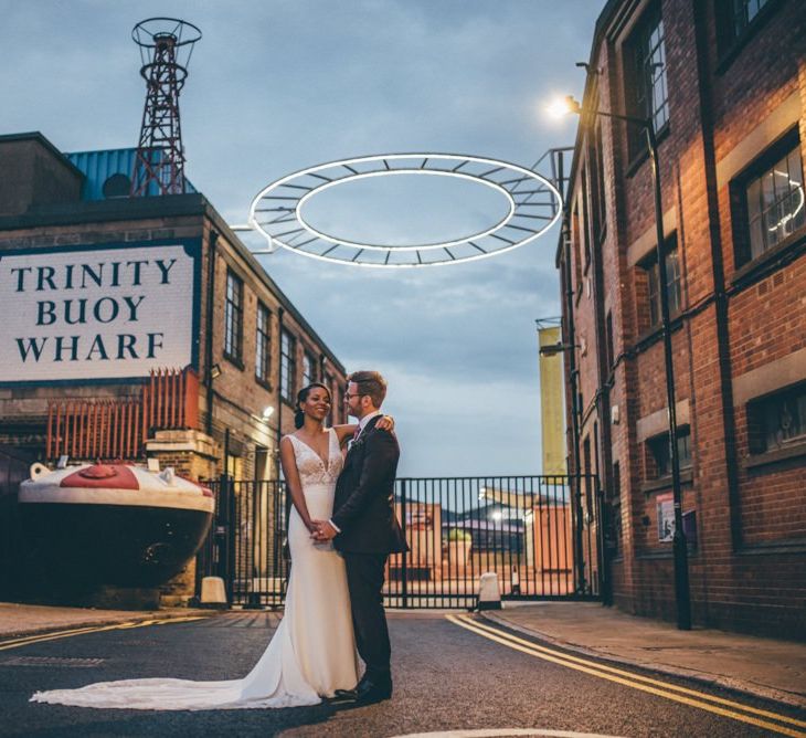 Bride and groom steal a moment at Trinity Buoy Wharf wedding reception with fairy light backdrop