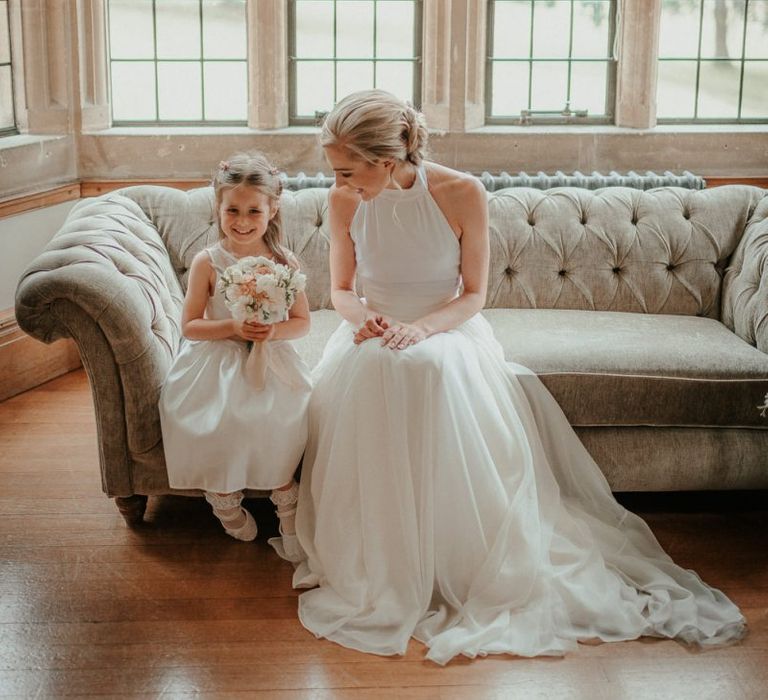 Bride Wears Halterneck Wedding Dress While Talking To Flower Girl