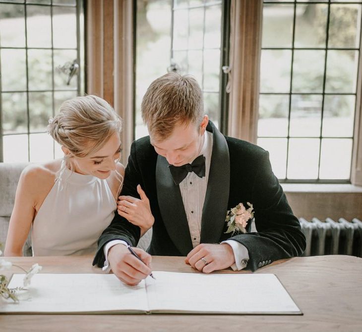 Bride And Groom Sign The Wedding Register At Coombe Lodge