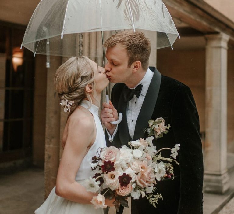 Bride and Groom Kiss Under Umbrella