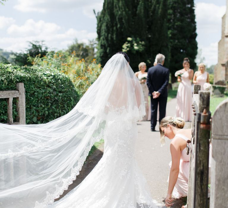 Bride in church courtyard in Pronovias wedding dress