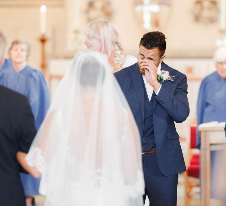 Emotional groom at the altar looking at his bride