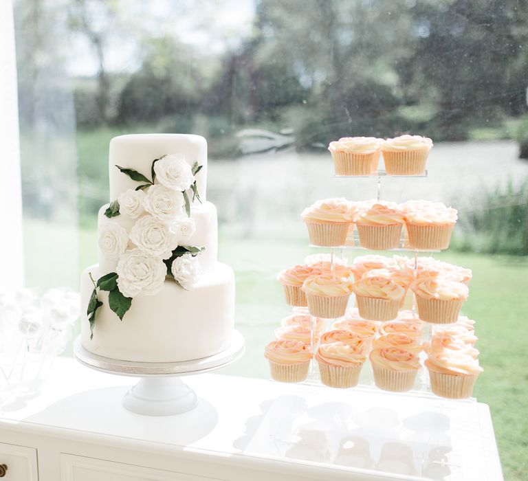 White wedding cake with rose wedding decor