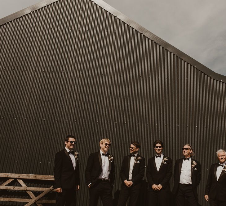 Groom with groomsmen in classic black tuxedo wedding suit