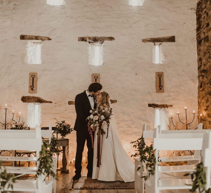 Bride and groom kiss during Wales wedding ceremony