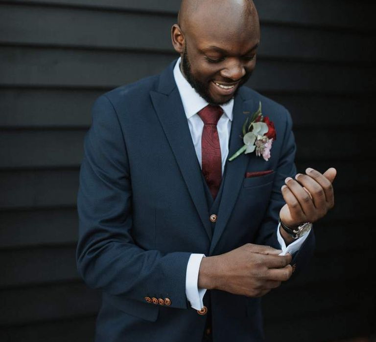 Groom in navy suit and burgundy tie for The Old Kent barn wedding