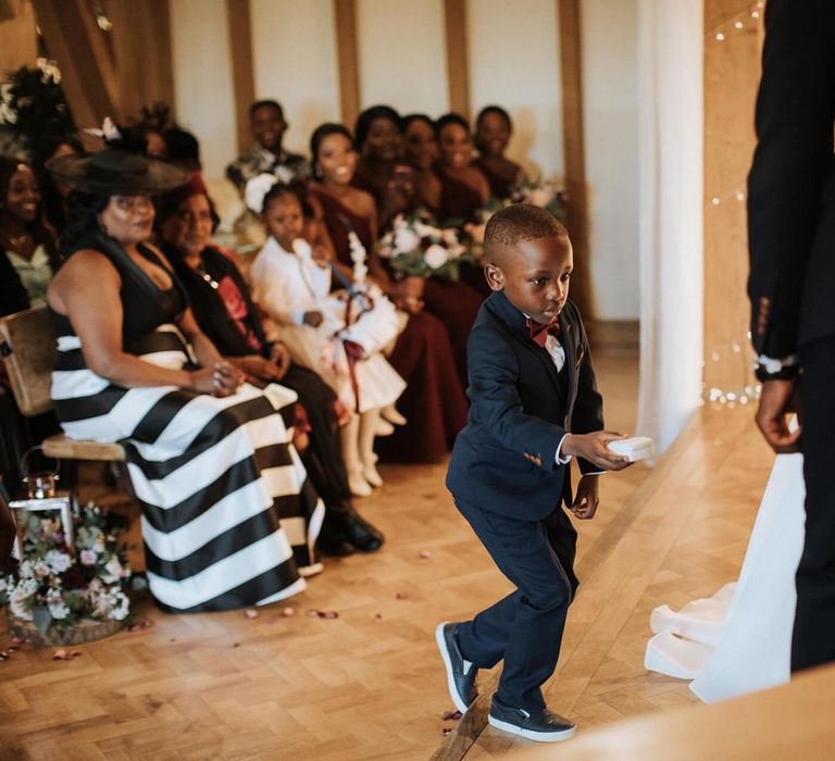 Little boy ring bearer in navy suit at The Old Kent Barn wedding