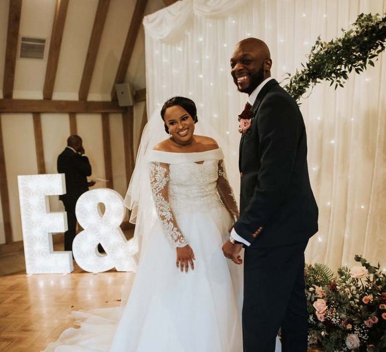 Bride and groom smiling during the wedding ceremony at The Old Kent Barn wedding venue