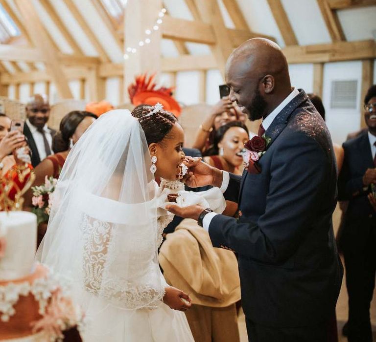 Groom feeding his bride the wedding cake at The Old Kent Barn wedding