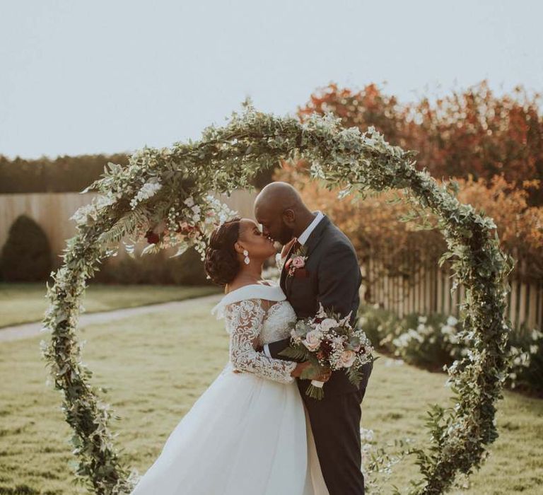 Bride and groom portrait in front of a floral moon gate