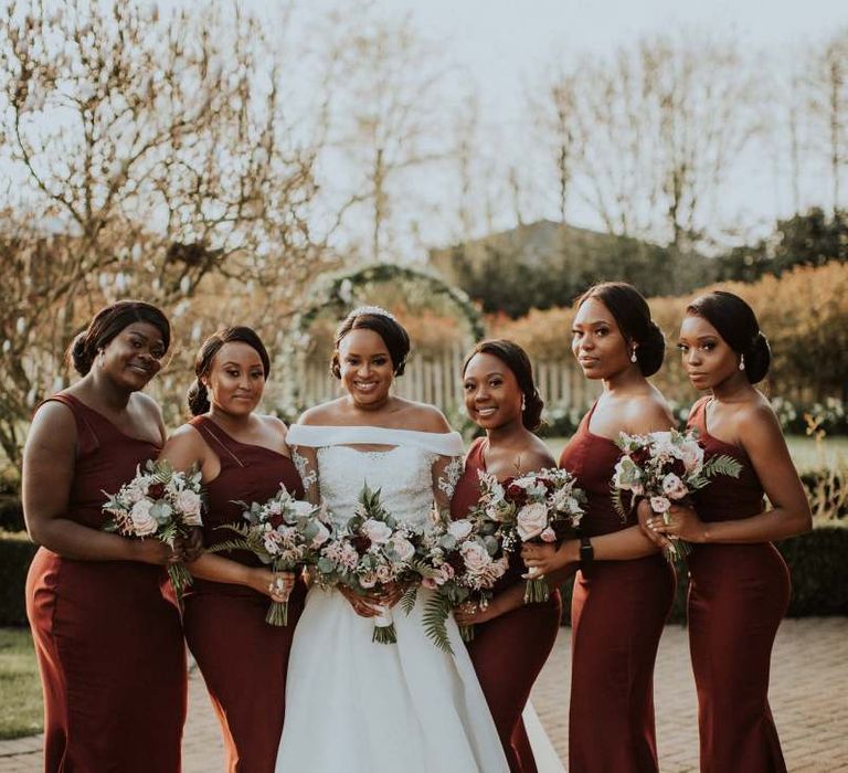 Bridal party portrait with bridesmaids in burgundy dresses at The Old Kent Barn wedding