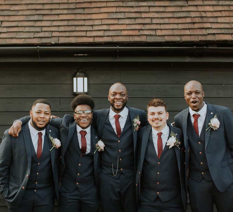 Groomsmen in navy suits and burgundy ties at The Old Kent Barn wedding