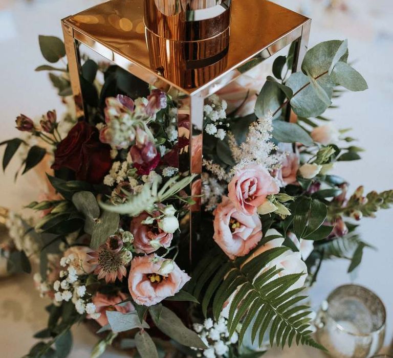 Lantern centrepiece filled with white and green wedding flowers