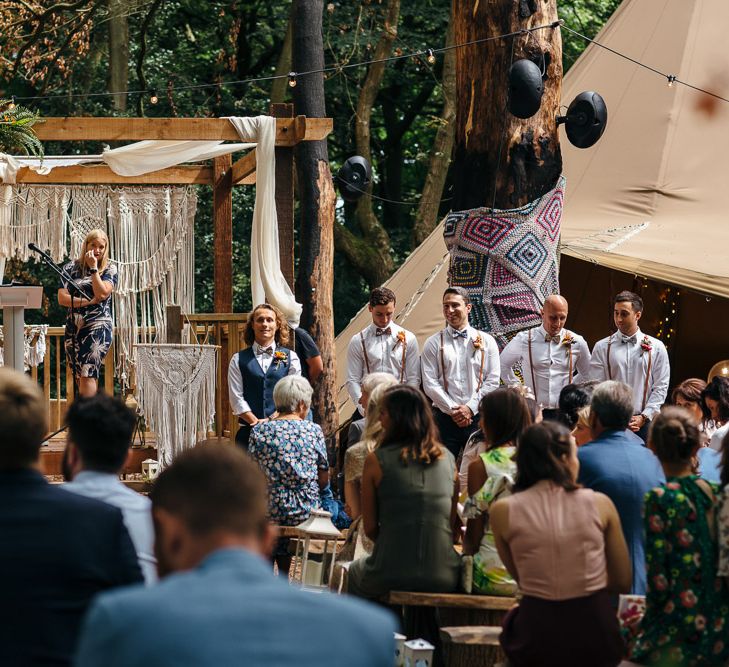 Wooden Altar Decorated with Macrame Hangings | Groom in Blue Waistcoat and Trousers with Colourful Patterned Bow Tie | Groomsmen in Shirts, Braces and Bow Ties | Woodland Wedding Ceremony at Lila's Wood | Macrame Decor, Vintage Caravan Photobooth and Five-Tier Naked Wedding Cake for Boho Wedding in Woodlands | Freckle Photography