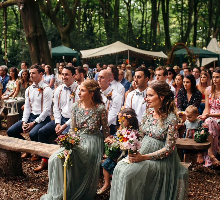 Bridesmaids in Dusky Green Needle &amp; Thread Dresses with Floral Embroidered Bodice and Long Sleeves | Colourful Wedding Bouquets with Sunflowers and Yellow Trailing Ribbons | Groomsmen in Shirts, Braces and Bow Ties | Woodland Wedding Ceremony at Lila's Wood | Macrame Decor, Vintage Caravan Photobooth and Five-Tier Naked Wedding Cake for Boho Wedding in Woodlands | Freckle Photography