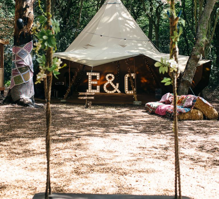 Tipi | Giant Letter Lights | Hay Bales and Blankets | Chandelier Hanging from Trees | Swing | Macrame Decor, Vintage Caravan Photobooth and Five-Tier Naked Wedding Cake for Boho Wedding in Woodlands | Freckle Photography