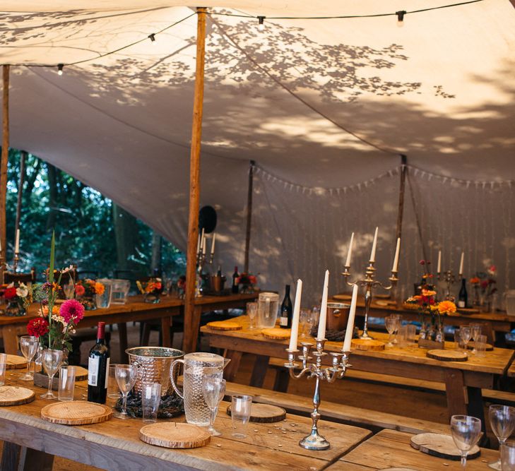 Rustic Wooden Tables | White Tapered Candles | Silver Candlestick Holders | Log Slice Place Settings | Bright Flowers in Glass Bottles | White Bunting | Silver Wine Buckets | Macrame Decor, Vintage Caravan Photobooth and Five-Tier Naked Wedding Cake for Boho Wedding in Woodlands | Freckle Photography