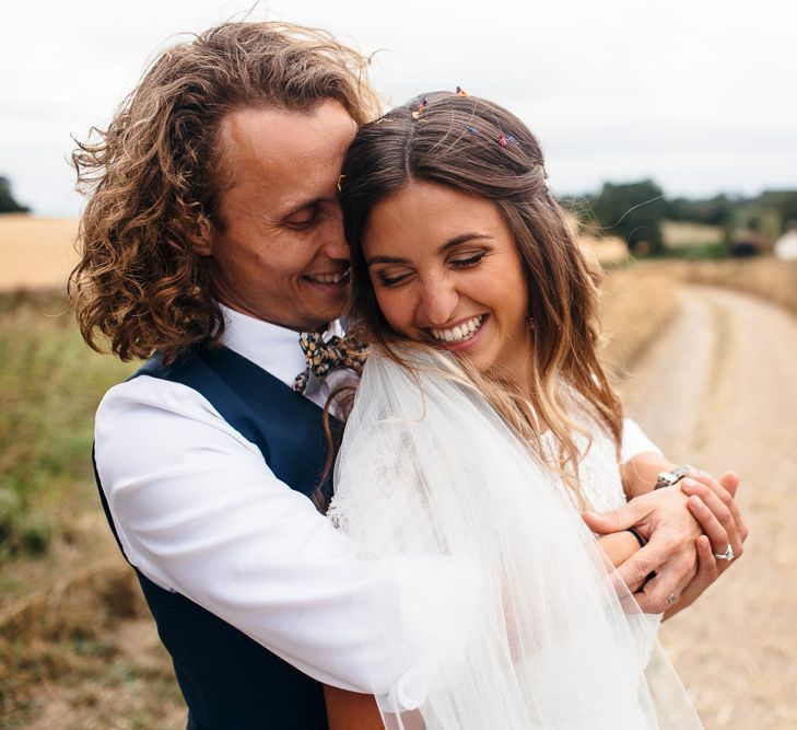 Bride in Lenora Dress by Wtoo Watters with Lace Cap Sleeves and Keyhole Back | Groom in Blue Waistcoat and Trousers with Colourful Patterned Bow Tie | Macrame Decor, Vintage Caravan Photobooth and Five-Tier Naked Wedding Cake for Boho Wedding in Woodlands | Freckle Photography