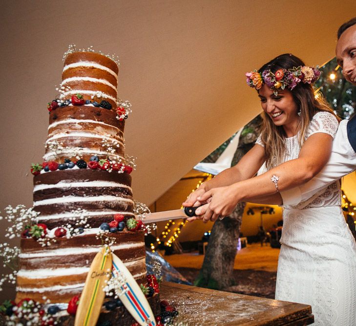 Bride in Lenora Dress by Wtoo Watters with Lace Cap Sleeves and Keyhole Back | Groom in Blue Waistcoat and Trousers with Colourful Patterned Bow Tie | Colourful Flower Crown | Five-Tier Naked Wedding Cake Decorated with Fruit and Gypsophila | Macrame Decor, Vintage Caravan Photobooth and Five-Tier Naked Wedding Cake for Boho Wedding in Woodlands | Freckle Photography