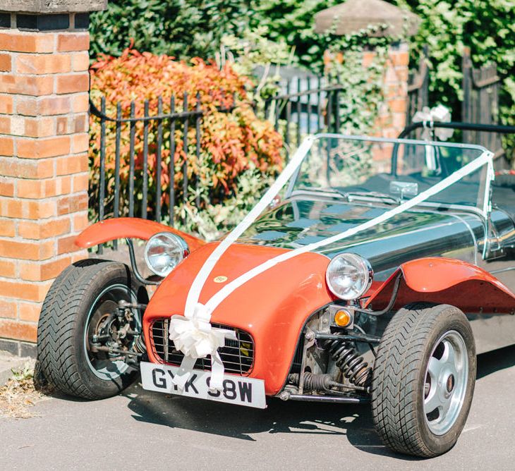 Red Kit Car Decorated with Ribbon | Arrival of the Bride | Hazel Gap Barn Wedding with Bride Arriving by Kit Car | Sarah-Jane Ethan Photography