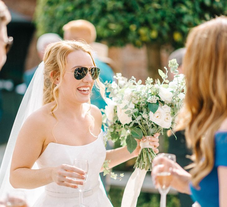 Bride in Strapless Sassi Holford Ballgown Wedding Dress with Belt | Bride Wearing Aviators | Bridal Bouquet with White Trailing Ribbon | White Flowers and Green Foliage | Hazel Gap Barn Wedding with Bride Arriving by Kit Car | Sarah-Jane Ethan Photography