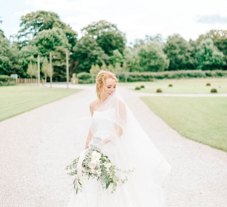 Bride in Strapless Sassi Holford Ballgown Wedding Dress with Belt | Loose Bouquet of White Flowers and Foliage with White Trailing Ribbon | Hazel Gap Barn Wedding with Bride Arriving by Kit Car | Sarah-Jane Ethan Photography