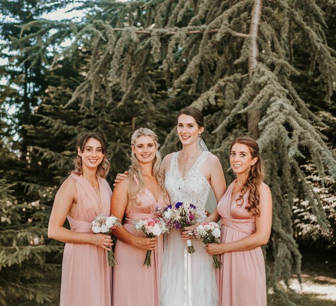 Bridal Party Portrait with Bridesmaids in Pink Oasis Dresses and Bride in Pronovias Danaia Wedding Dress