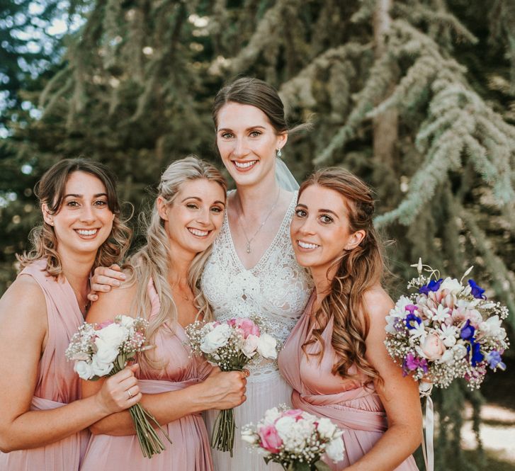 Bridal Party Portrait with Bridesmaids in Pink Oasis Dresses and Bride in Pronovias Danaia Wedding Dress