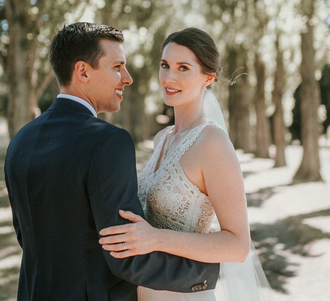 Bride in Pronovias Danaia Wedding Dress and Groom in Moss Bros. Suit  Embracing in The Woods