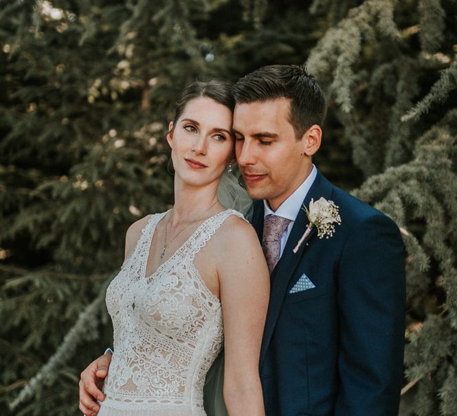 Bride in Pronovias Danaia Wedding Dress and Groom in Moss Bros. Suit Embracing