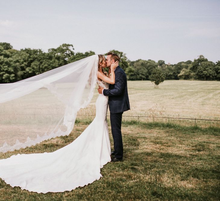 Bride in Vicenta Pronovias Wedding Dress and Groom in Navy Check Moss Bros Suit