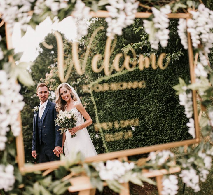 Gold Framed Mirror Wedding Welcome Sign with Reflection of Bride and Groom