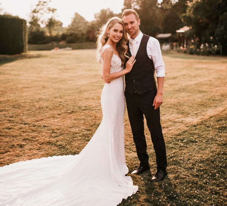 Golden Hour Portrait with Bride in Vicenta Pronovias Wedding Dress and Groom in Navy Check Moss Bros Suit