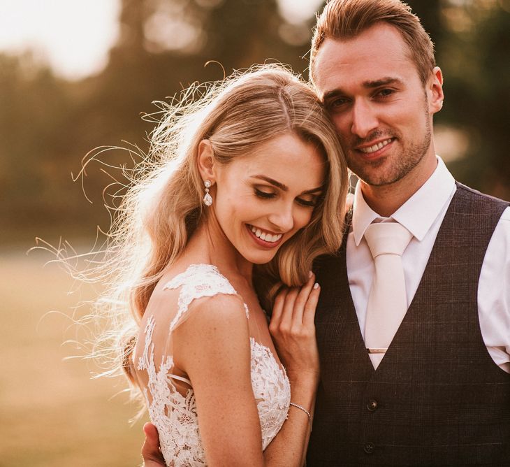 Sunset Portrait with Bride in Vicenta Pronovias Wedding Dress and Groom in Navy Check Moss Bros Suit