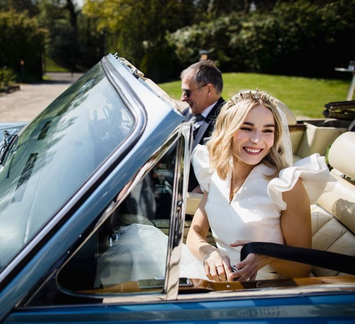 Bride arrives at venue in car with roof top down