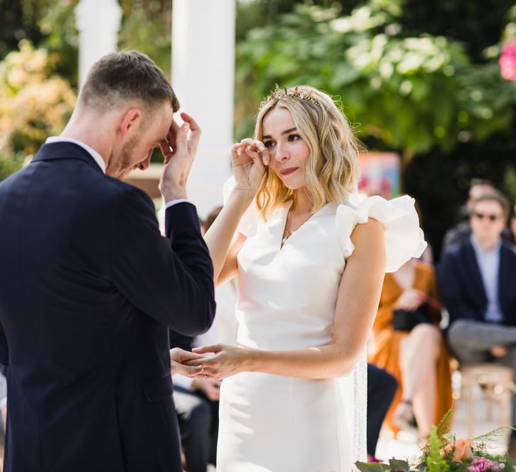 Bride wipes tear as they exchange vows