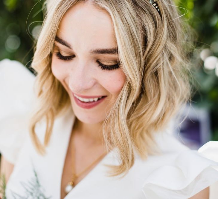 Stunning bride with crown and ruffle sleeved dress with white bridesmaid dresses