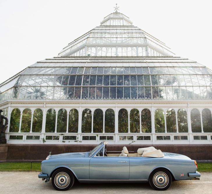 Wedding car parked in front of glass house wedding venue