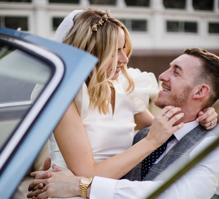 Bride and groom steel a moment in wedding car