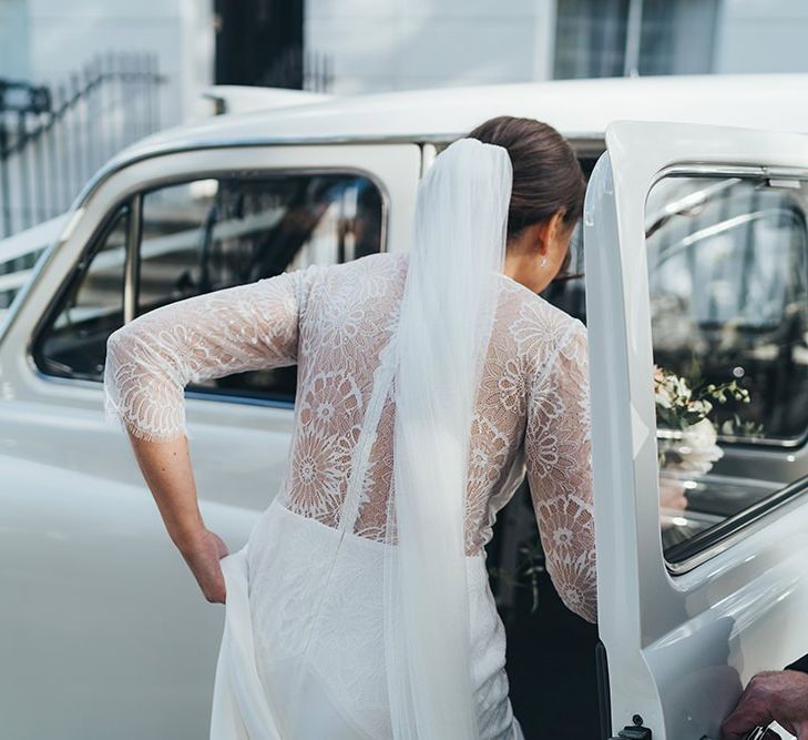 Bride getting in a Vintage London Taxi in a Lace Back Wedding Dress