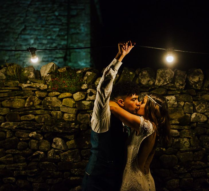 Festoon Lights | Bride in Daughters of Simone Lace Gown | Groom in Tweed Suit | Brightly Coloured Festival Wedding with Outdoor Humanist Ceremony &amp; Tipi Reception on the Yorkshire Dales | Tim Dunk Photography